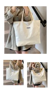 Dettaglio della trama in velluto a coste bianco della borsa tote e del logo patch