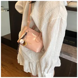 Detail of pink crossbody tote bag with a sports charm and adjustable shoulder strap