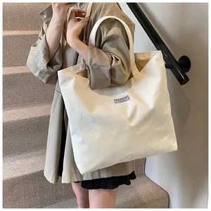 Dettaglio della borsa tote in velluto a coste bianco con trama a coste e logo moda