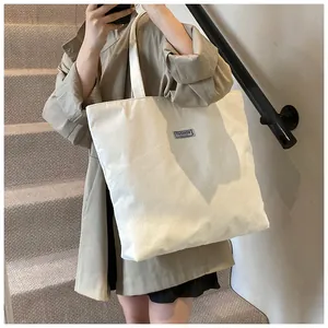 Dettaglio della borsa tote in velluto a coste bianco con texture morbida ed etichetta