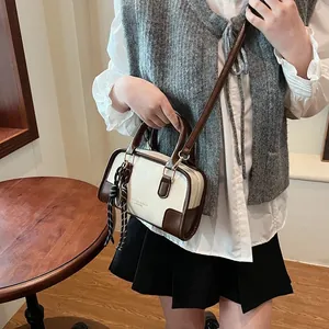 Retro cream and brown boston bag with twin handles and stylish checkered scarf accessory