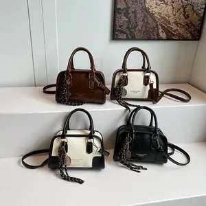 Chic leather Boston bag in four colors with shoulder strap and tennis racket charm