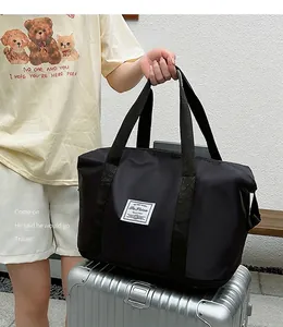 Detail der wasserdichten schwarzen Reisetasche mit Griffen auf silbernem Koffer