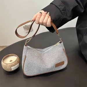 Chic gray textured fabric shoulder bag with brown leather trim and golden metal hardware