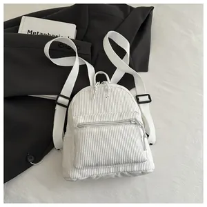 Detail eines weißen Cord-Mini-Rucksacks mit vertikaler Textur und Reißverschlusstasche
