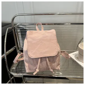 Dettaglio di un mini zaino rosa chiaro con tessuto plissettato e chiusura a coulisse