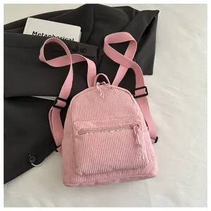 Nahaufnahme des rosa Cord-Minirucksacks mit verstellbaren Trägern auf schickem Hintergrund