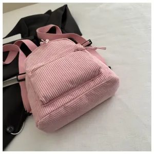 Detail der Textur des rosa Cord-Minirucksacks mit Reißverschlusstasche und Riemen