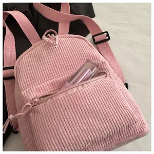 Nahaufnahme des rosa Cord-Mini-Rucksacks mit Lipgloss in der praktischen Fronttasche
