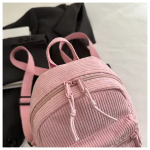 Detailansicht der rosa Cord-Textur und Doppelreißverschlüsse am leichten Rucksack