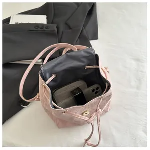 Spazio interno dello zainetto rosa con coulisse, cellulare, portafoglio e rossetto