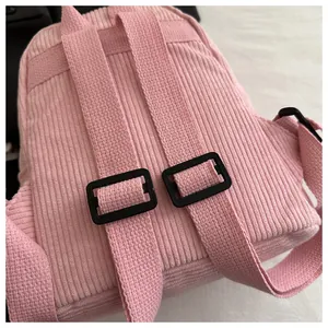 Detail eines rosa Cord-Rucksacks mit verstellbaren Schultergurten und weicher Textur