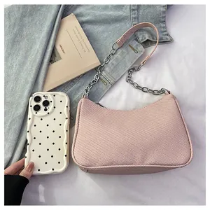 Pink crescent underarm bag with silver chain and denim jacket in lifestyle setting