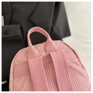 Detailaufnahme des rosa Cord-Rucksacks mit strukturiertem Stoff und Tragegriff oben