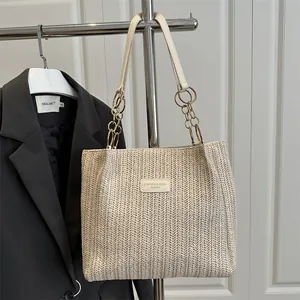 Straw woven bucket tote bag with gold chain strap for summer beach holidays