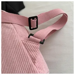 Detailansicht aus rosa Cordstoff mit verstellbarer schwarzer Schnalle und Gurtband