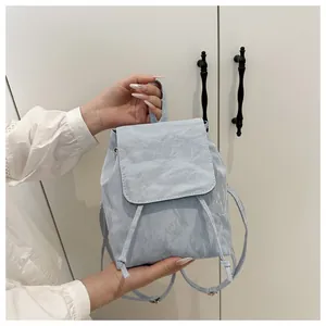 Dettaglio mini zaino azzurro con texture stropicciata e chiusura a coulisse