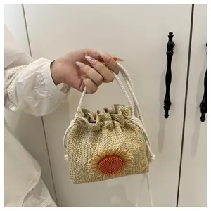 Dettaglio della borsa a secchiello in paglia con girasole 3D e manico in cotone a coulisse