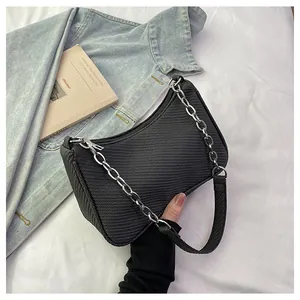 Detailed view of black textured herringbone crossbody bag with silver chain and wide strap