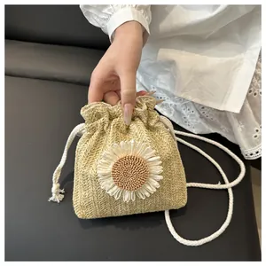 Dettaglio borsa a secchiello in paglia gialla con girasole bianco e tracolla in corda