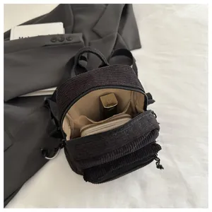 Innenansicht des schwarzen Cord-Rucksacks mit beigem Futter und Aufbewahrungsfächern