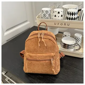Detail der braunen Cord-Mini-Rucksackstruktur mit Front-Reißverschluss und Kordelzug