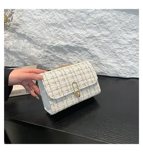 Vue détaillée du sac bandoulière en tweed blanc avec fermoir et chaîne dorés