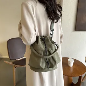 Minimalistische donkergroene nylon emmertas met trekkoordsluiting en schouderriem