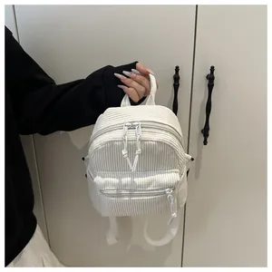 Nahaufnahme der weißen Cord-Mini-Rucksack-Textur mit Reißverschlüssen und Webgriff