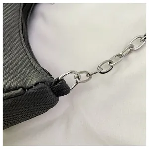 Macro shot of dark striped fabric texture and silver chain detail on small square bag