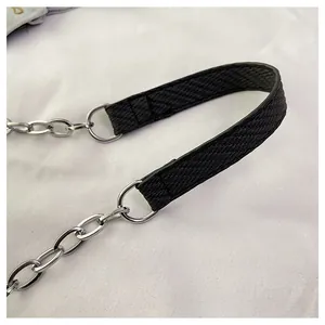 Detail of black textured strap with silver metal D-ring and minimalist chain link