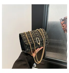 Détail de la texture en tweed tissé et de la boucle en métal doré sur le sac à bandoulière
