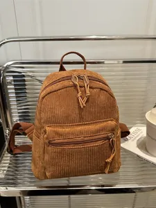 Minimalistischer brauner Cord-Rucksack für Damen in modernem Regal mit Accessoires