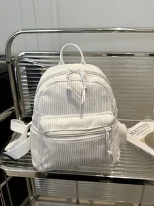 Minimalistischer cremefarbener Cord-Rucksack mit Fronttasche und Baumwollgurten im Regal