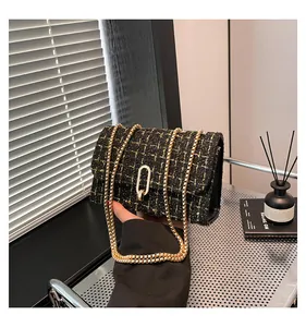 Détail du sac bandoulière en tweed avec chaîne dorée et fermoir ovale en décor élégant
