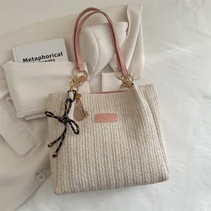 Straw bucket tote bag with pink leather straps and letter logo patch in beige weave