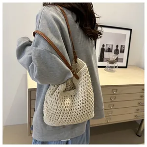 Detailed macro view of the crochet mesh texture and brown leather strap on the tote bag