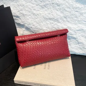 Women's burgundy woven leather crossbody pillow bag with magnetic flap closure