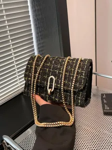 Sac bandoulière élégant en tweed noir et doré avec chaîne dorée et fermoir rotatif