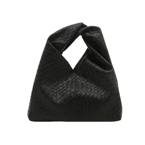 Sac fourre-tout noir tressé avec poignée à nœud sur fond blanc style minimaliste