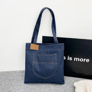 Sac cabas en denim bleu foncé avec accent en cuir et poche avant fonctionnelle