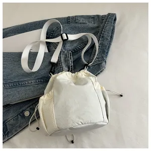 Detail der cremefarbenen Nylon-Beuteltasche mit Kordelzug und seitlicher Netztasche
