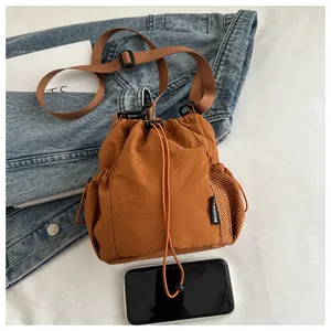 Detailansicht der braunen Nylon-Beuteltasche mit Netztasche und modischem Etikett