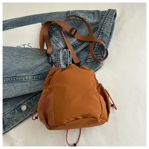 Detailansicht der karamellbraunen Nylon-Beuteltasche mit Mesh-Seitentasche