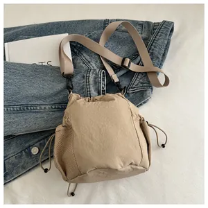 Detail der khakifarbenen Nylon-Beuteltasche mit Netzseitentaschen und verstellbarem Gurt