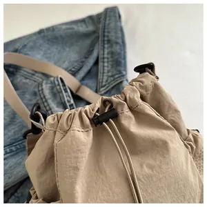 Detail der khakifarbenen Nylon-Beuteltasche mit Netzseite und Kordelzugverschluss