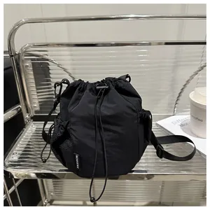 Details der schwarzen Nylon-Beuteltasche mit Fashion-Label und seitlicher Netztasche