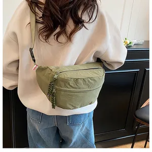Rear view of a model wearing the green nylon crossbody chest bag with adjustable strap