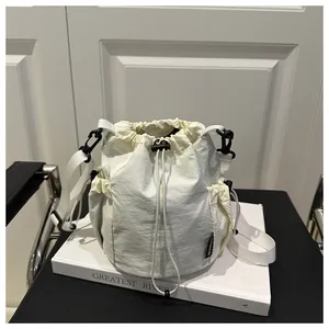 Detailansicht der cremefarbenen Nylon-Beuteltasche mit seitlicher Netztasche und Logo