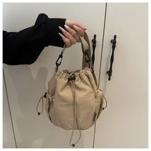 Detail der khakifarbenen Nylon-Beuteltasche mit Mesh-Seitentaschen und Kordelzug